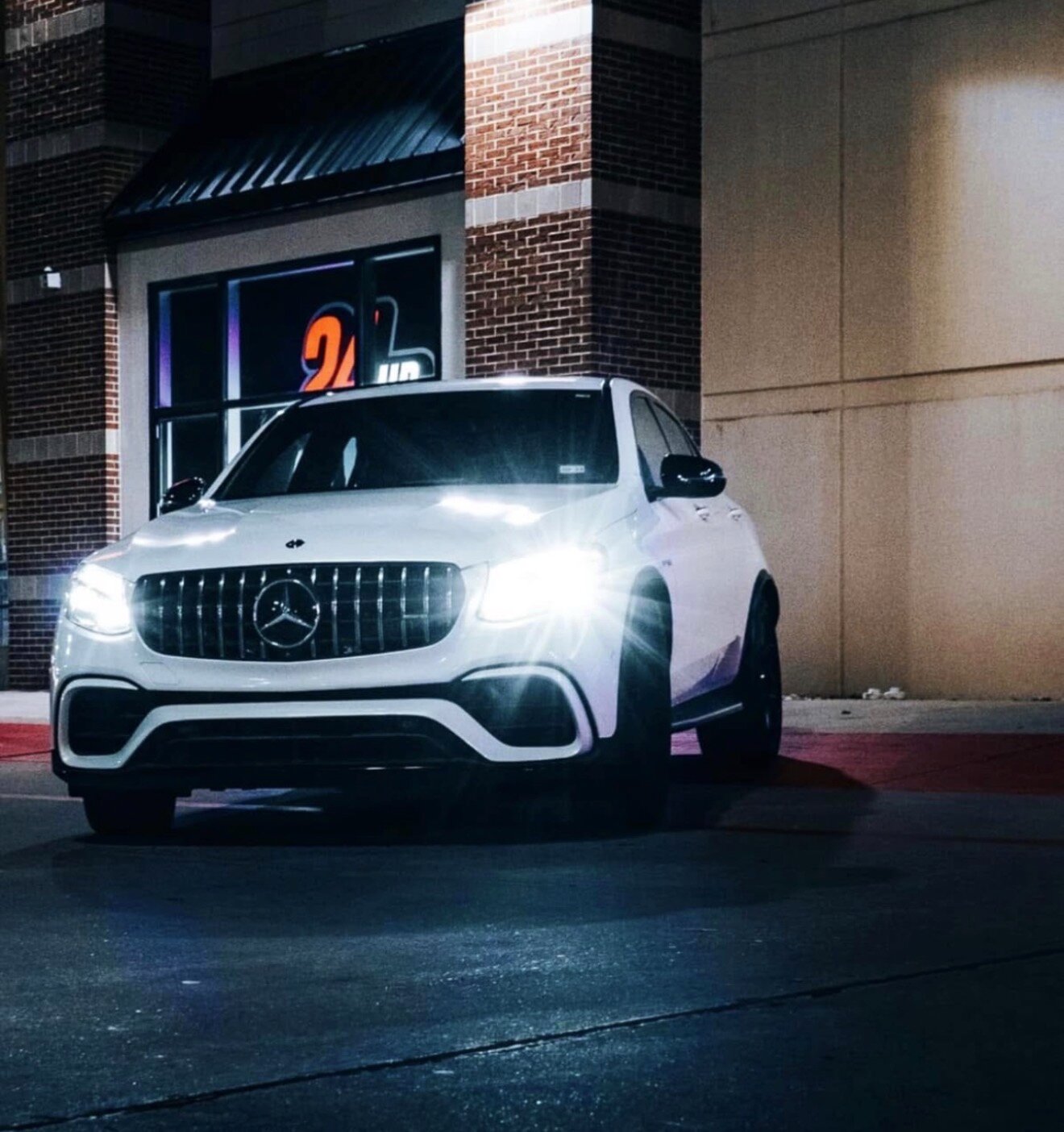 Mercedes-AMG GLC 63 S dramatic front three-quarter shot with headlights on at night