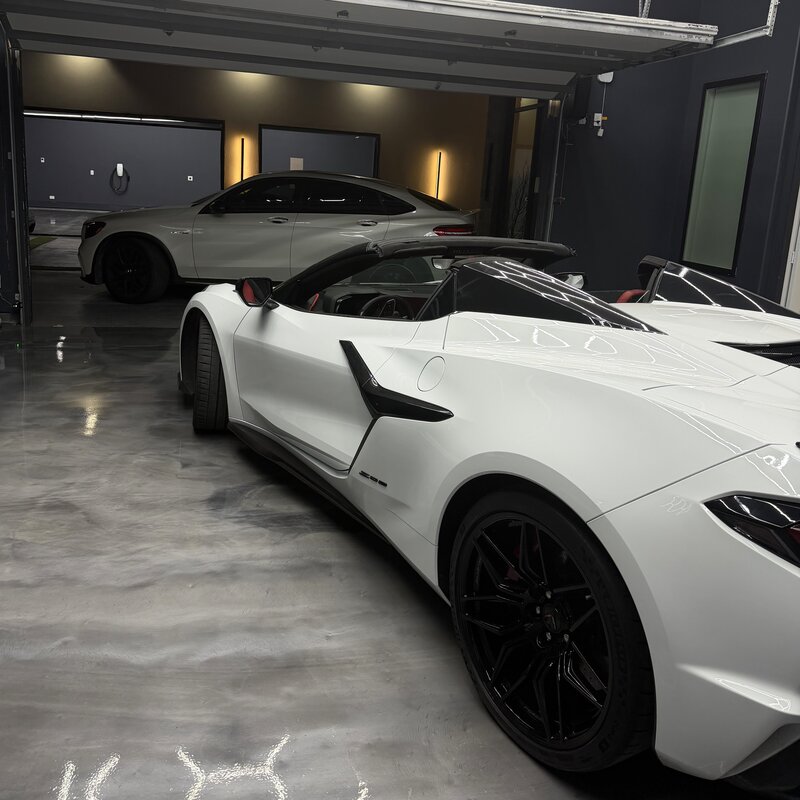 White Corvette Z06 lineup inside a polished garage