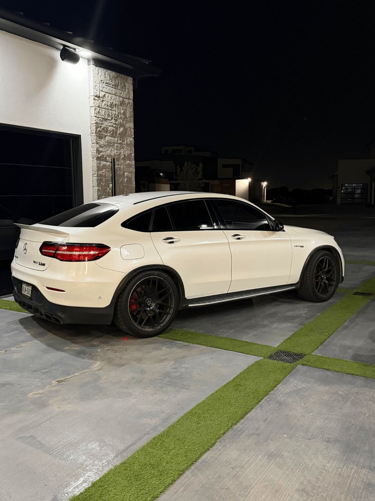 Mercedes-AMG GLC 63 S rear three-quarter in a modern home driveway at night
