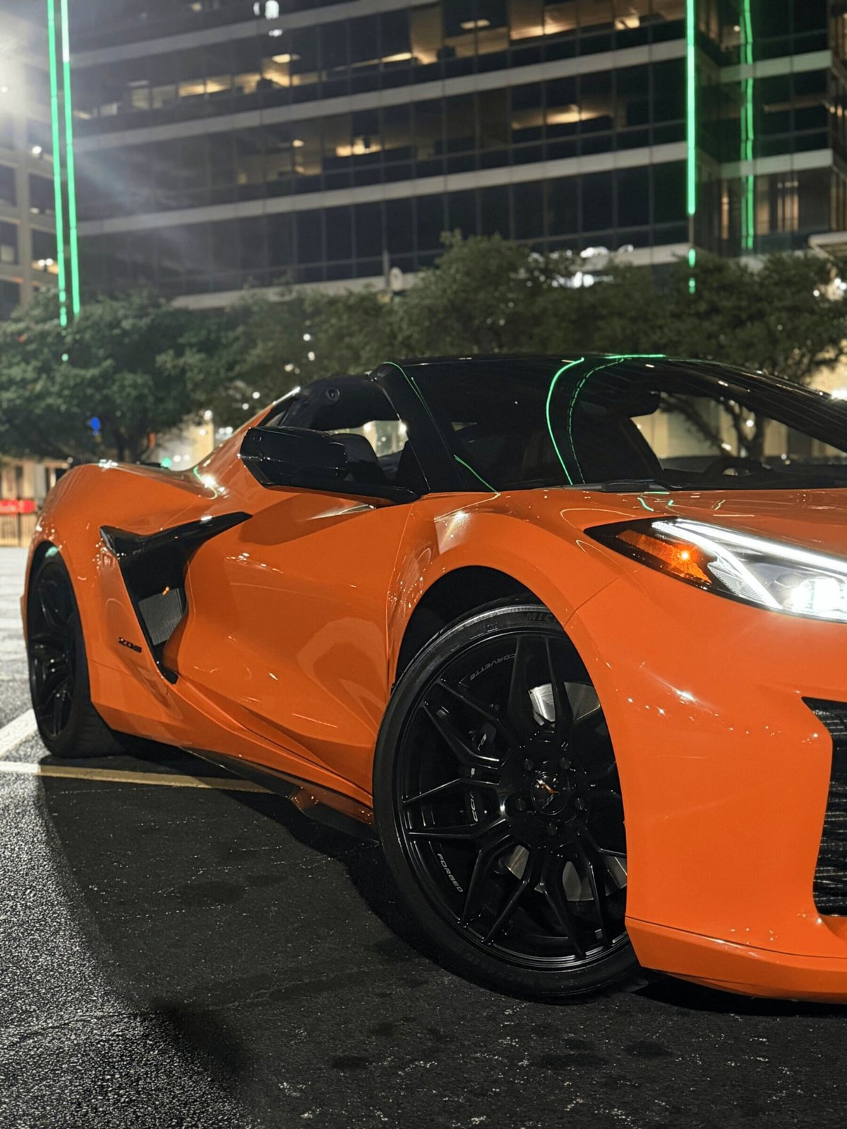 Corvette Z06 2LZ forged wheel and fender detail against a downtown skyline at night